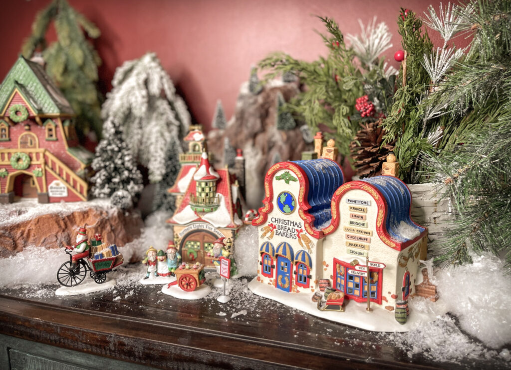 Shows step 5 of setting up a small Christmas village display: adding snow